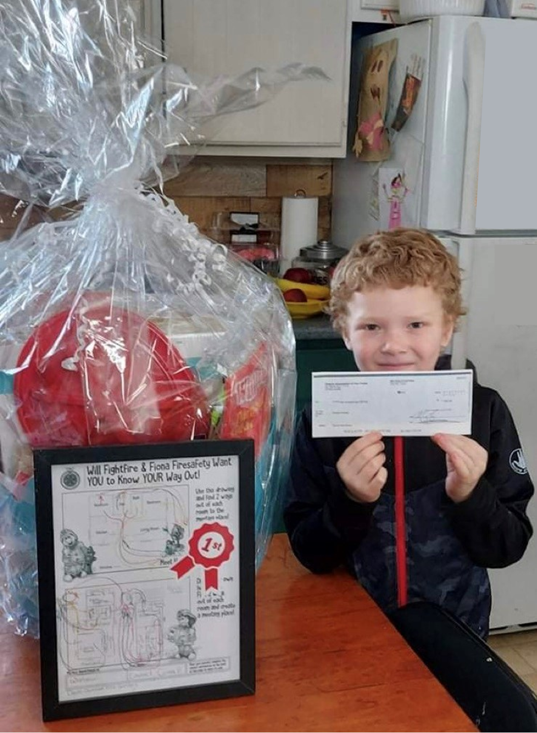 2021 Fire Prevention Week home escape plan contest winner with his prizes.